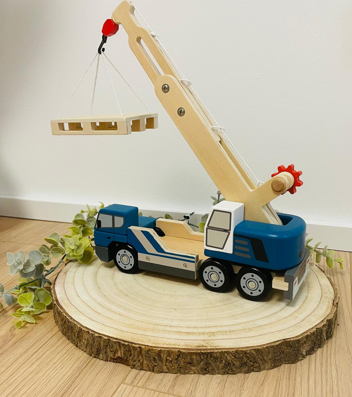Kranwagen mit Palette aus Holz
